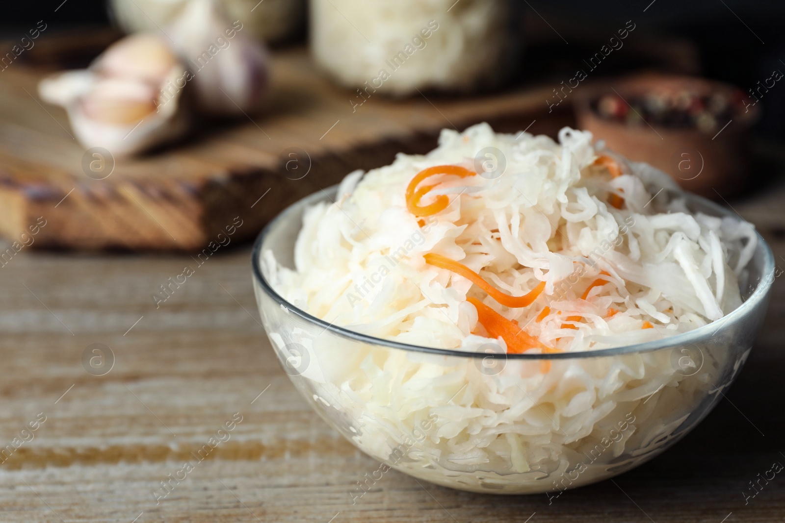 Photo of Tasty fermented cabbage on wooden table, closeup