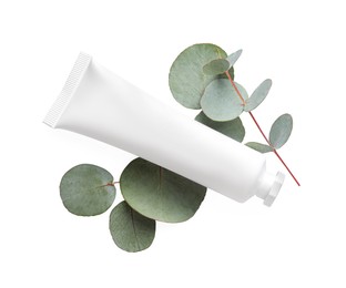 Tube of hand cream and eucalyptus on white background, top view