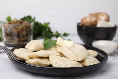 Photo of Delicious dumplings (varenyky) with tasty filling, butter and parsley served on white table, closeup