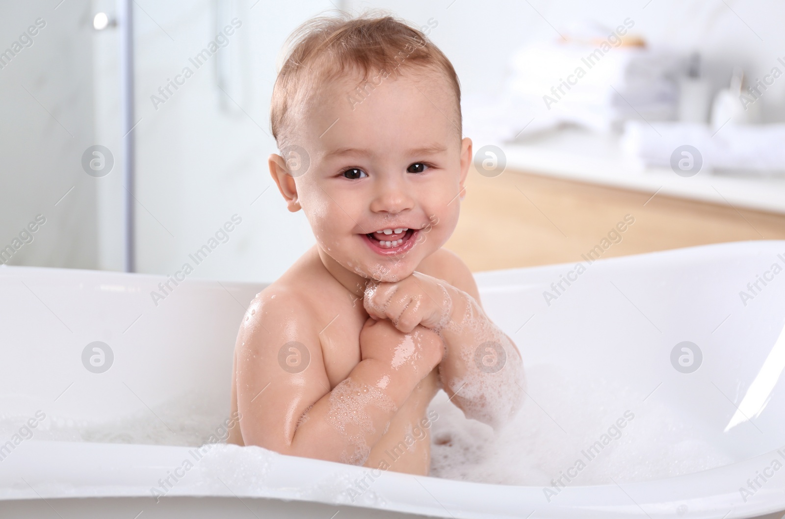 Photo of Cute little baby in bathtub at home