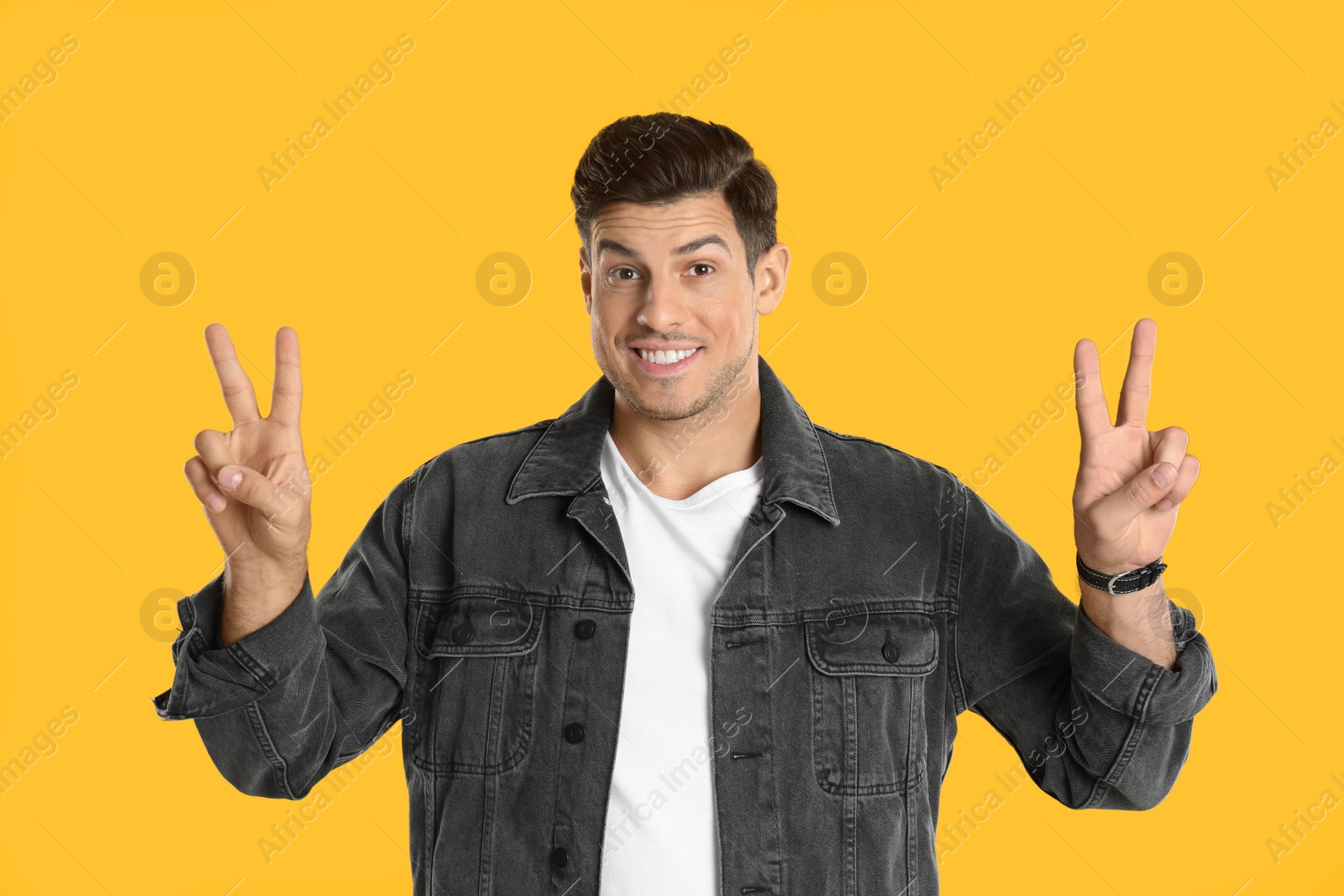 Photo of Man showing number four with his hands on yellow background