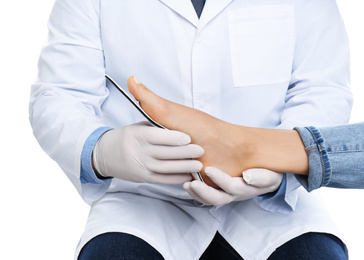 Photo of Male orthopedist fitting insole on patient's foot against white background, closeup
