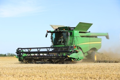 Photo of Modern combine harvester working in agricultural field