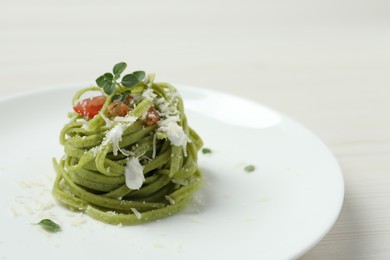 Photo of Tasty tagliatelle with spinach and cheese served on white wooden table, closeup. Exquisite presentation of pasta dish