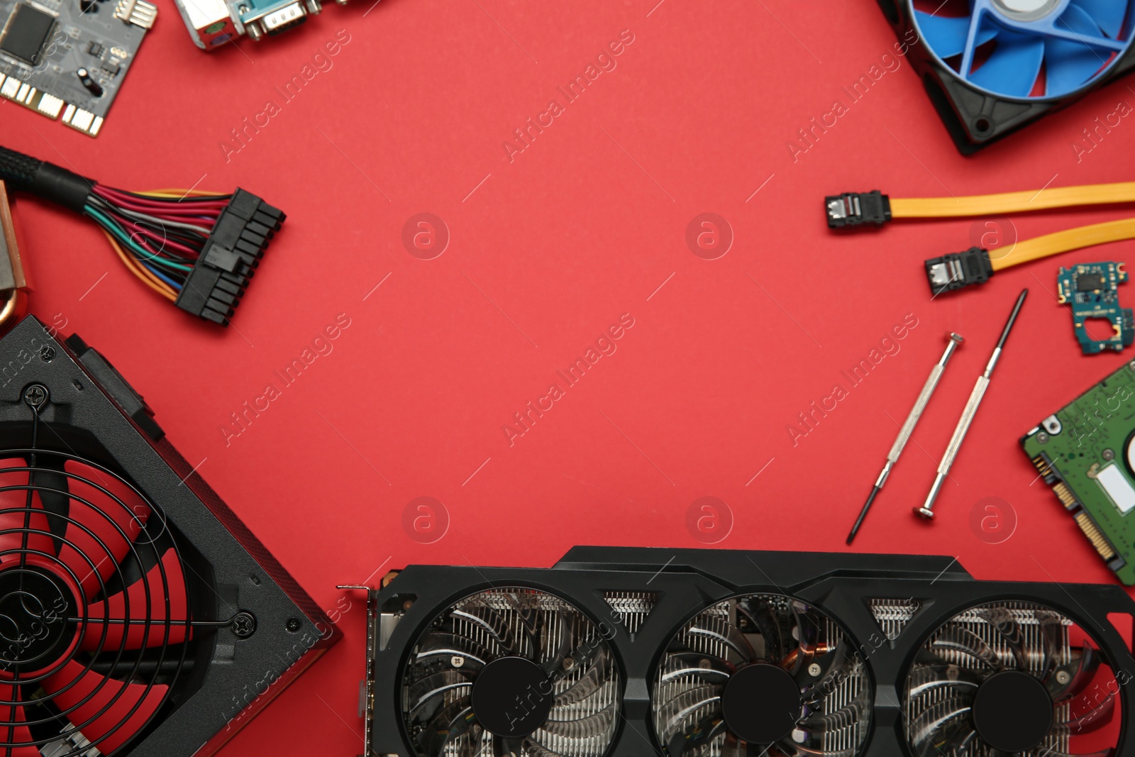 Photo of Graphics card and other computer hardware on red background, flat lay. Space for text