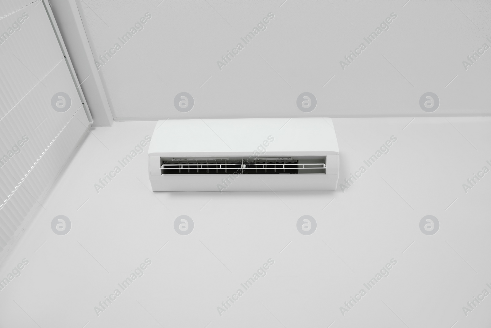 Photo of Modern air conditioner on white wall indoors, low angle view. Space text copy