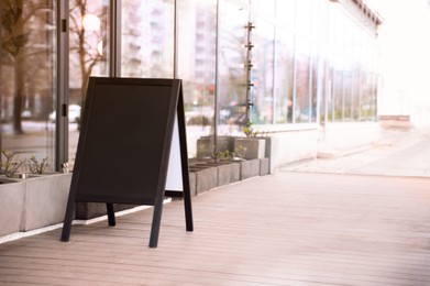 Photo of Empty A-board near building outdoors. Mockup for design