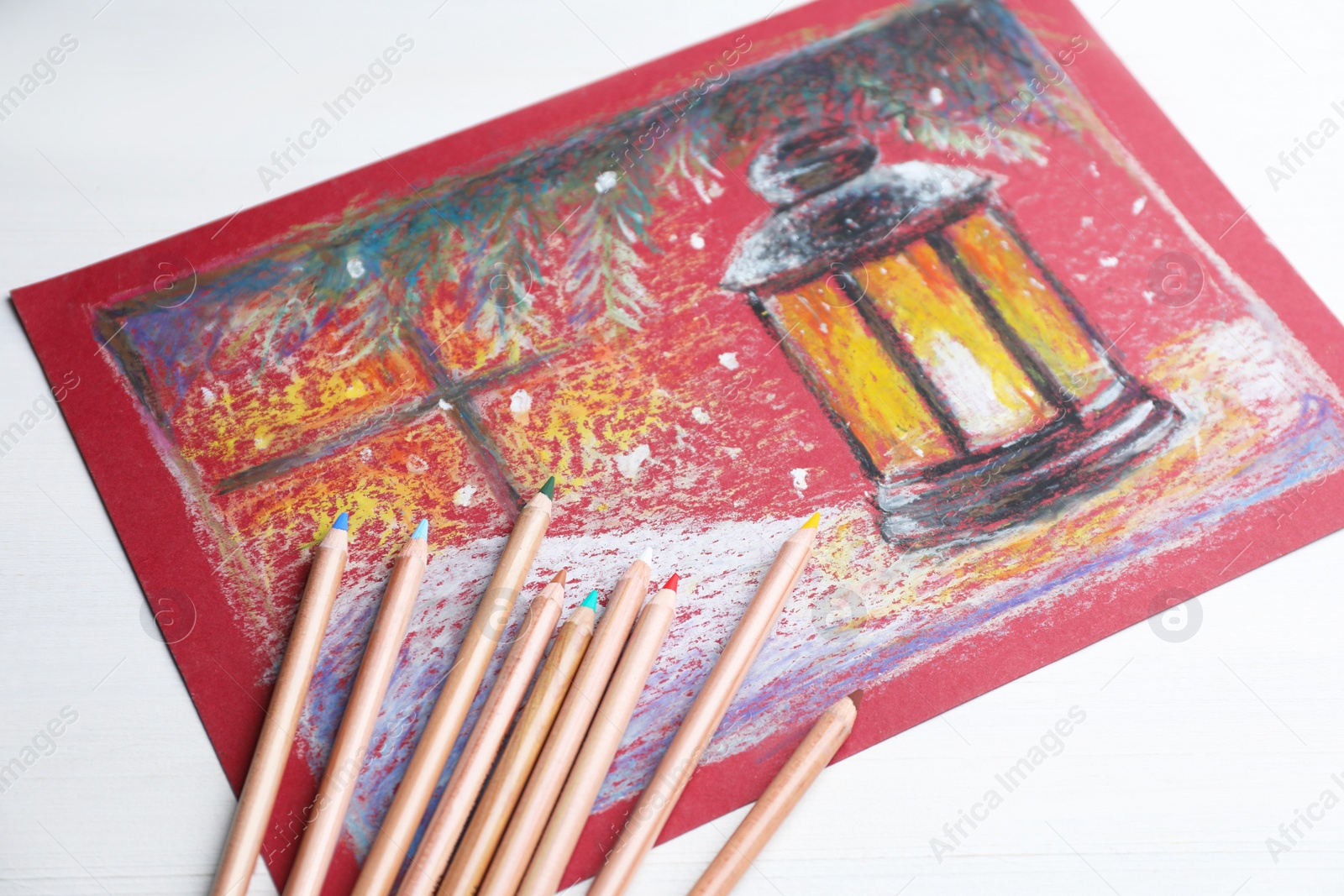 Photo of Colorful pastel pencils and beautiful painting on white wooden table