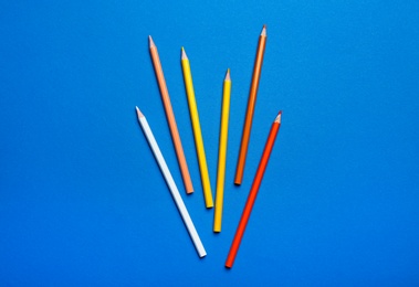 Photo of Color pencils on blue background, flat lay