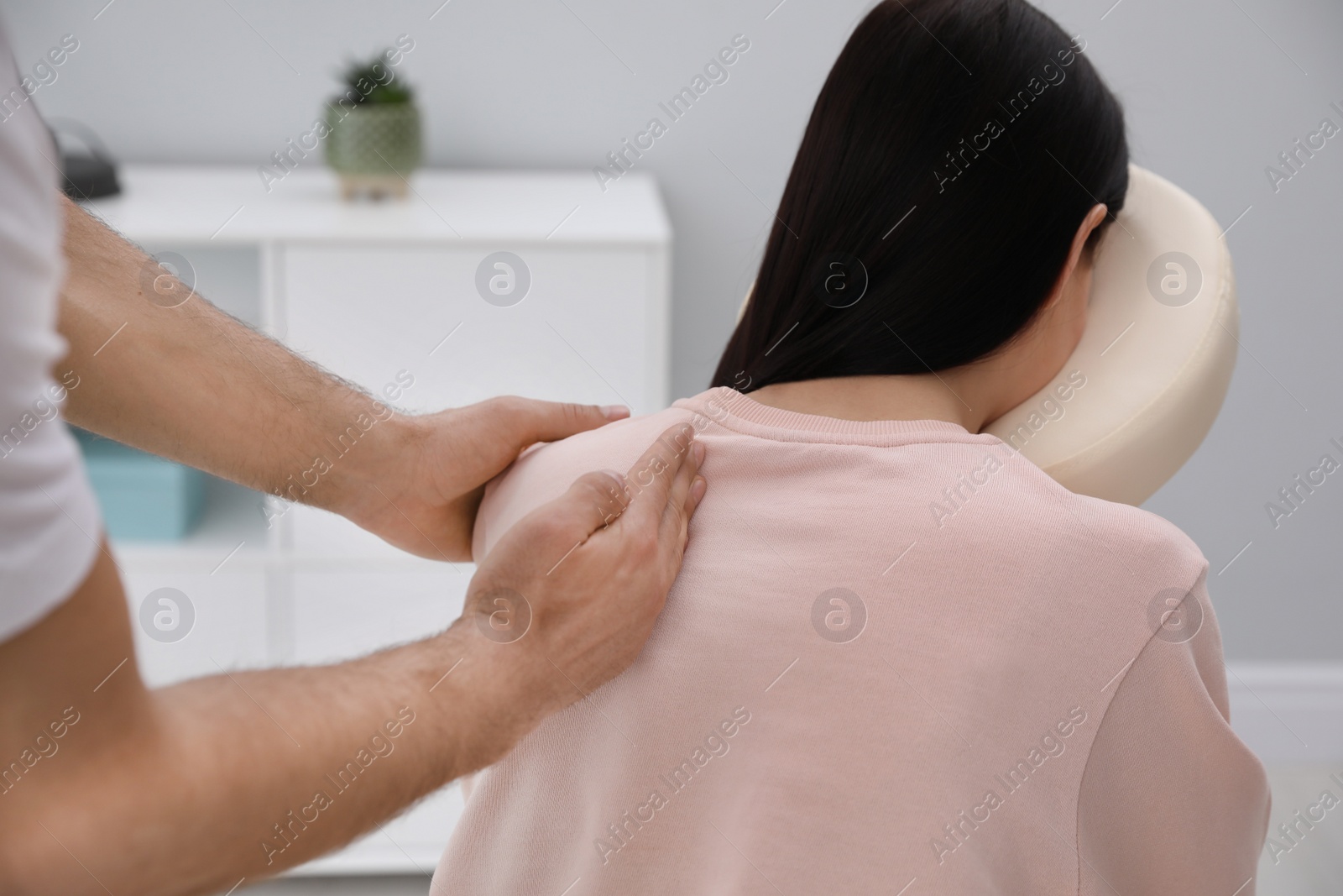 Photo of Woman receiving massage in modern chair indoors, closeup