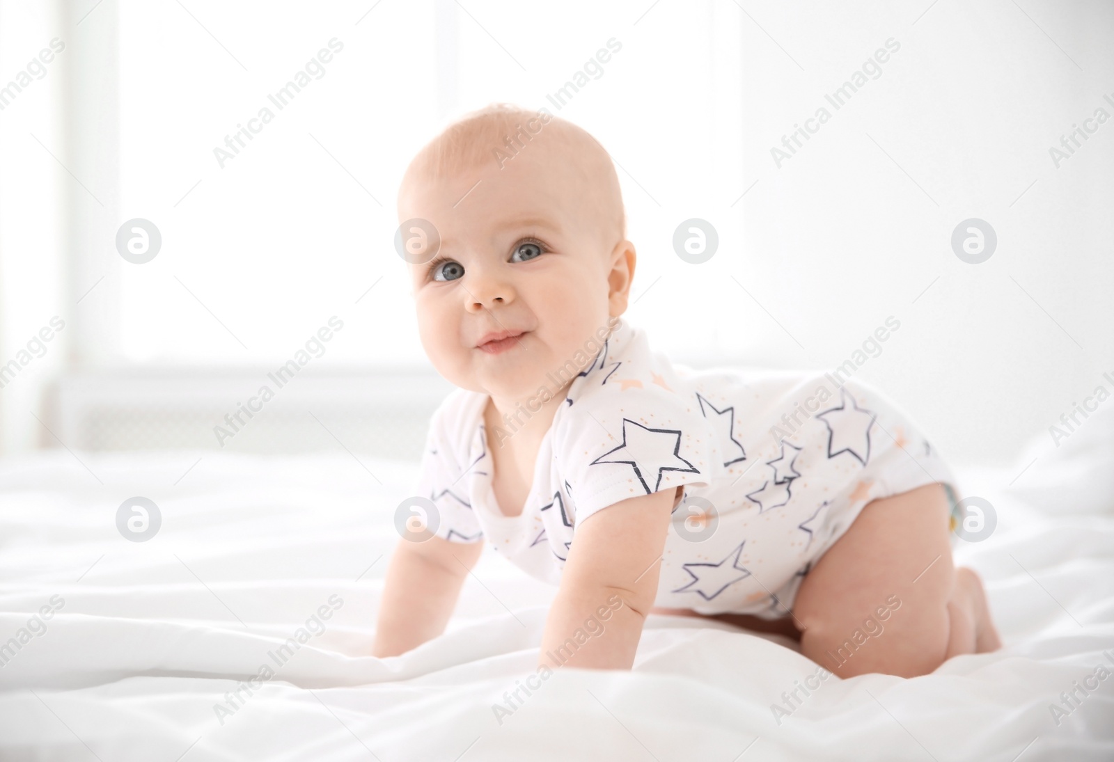 Photo of Cute little baby crawling on bed at home