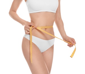 Photo of Slim young woman with smooth gentle skin in underwear measuring body on white background, closeup