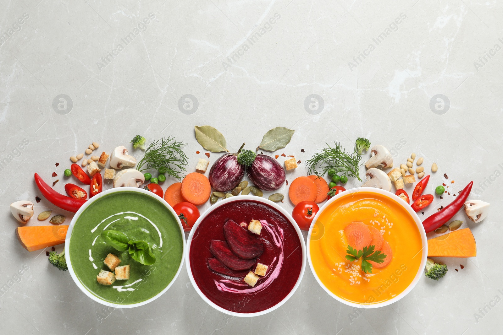 Photo of Various cream soups, ingredients and space for text on grey background, flat lay. Healthy food