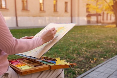 Photo of Woman drawing with soft pastels on street, closeup