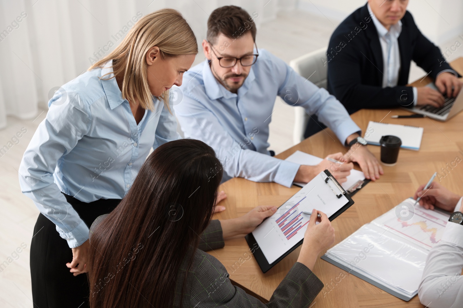 Photo of Businesswoman showing chart on meeting in office