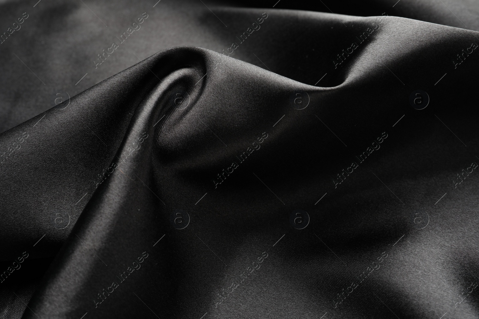 Photo of Crumpled black silk fabric as background, closeup