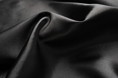 Photo of Crumpled black silk fabric as background, closeup