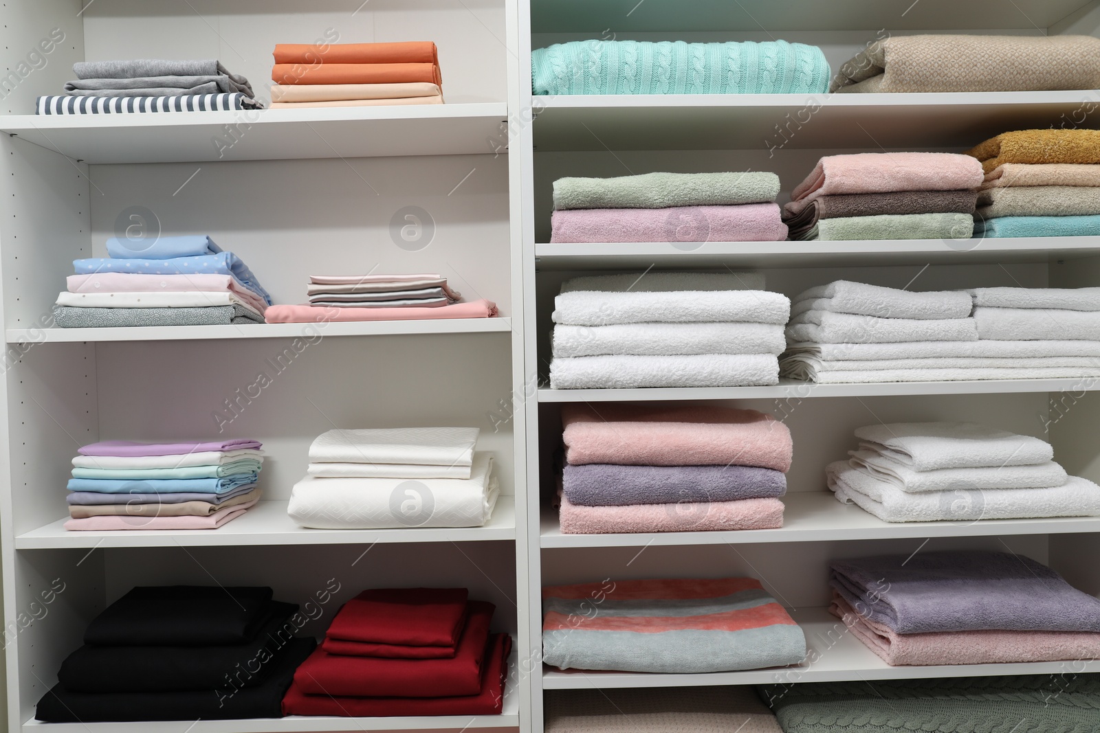 Photo of Different color linens on shelves in shop