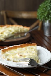 Photo of Tasty leek pie served on wooden table