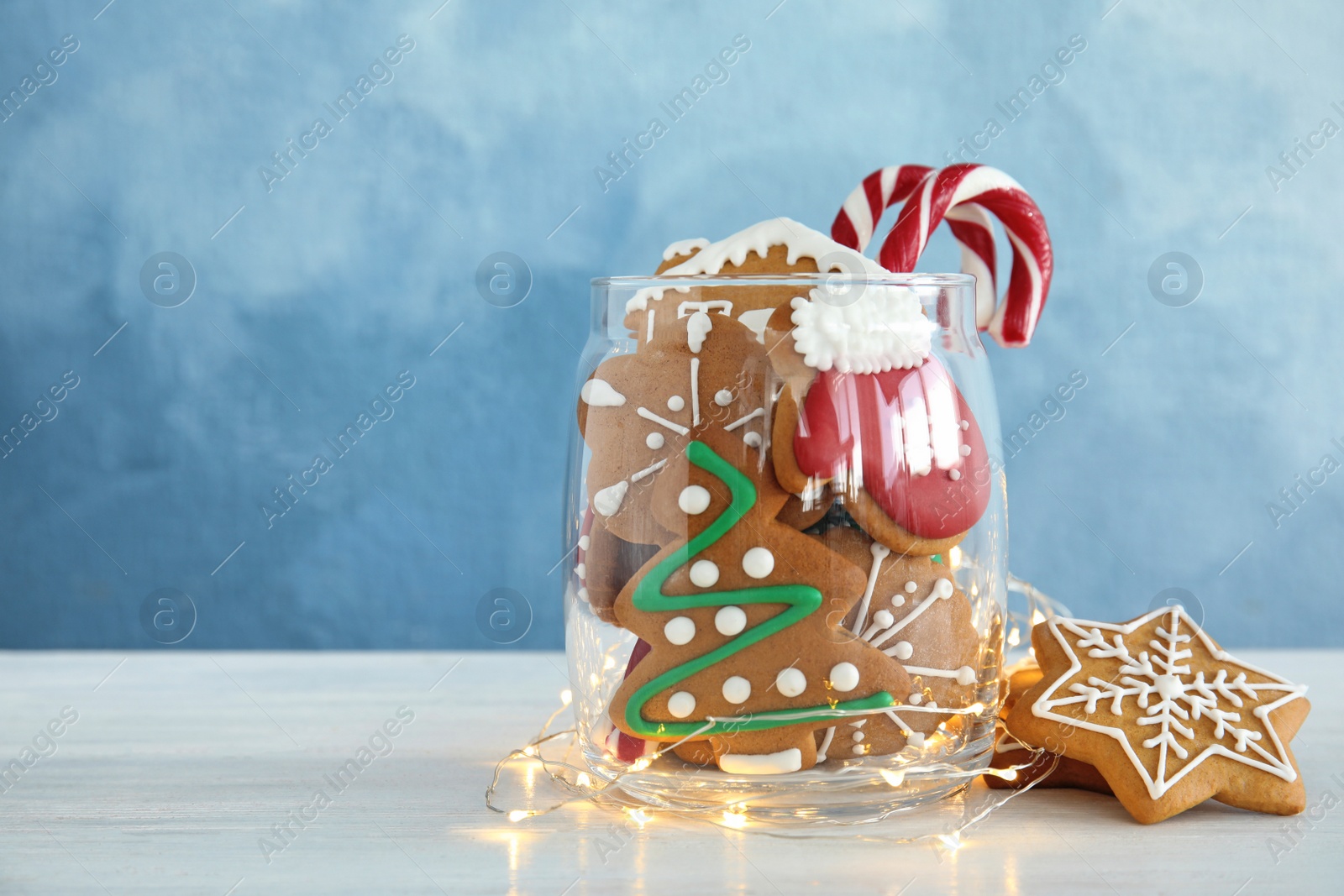 Photo of Glass jar with tasty homemade Christmas cookies on table