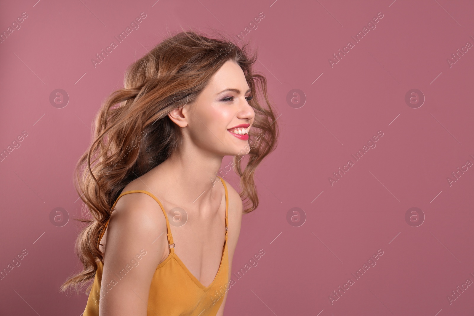 Photo of Portrait of young woman with long beautiful hair on color background