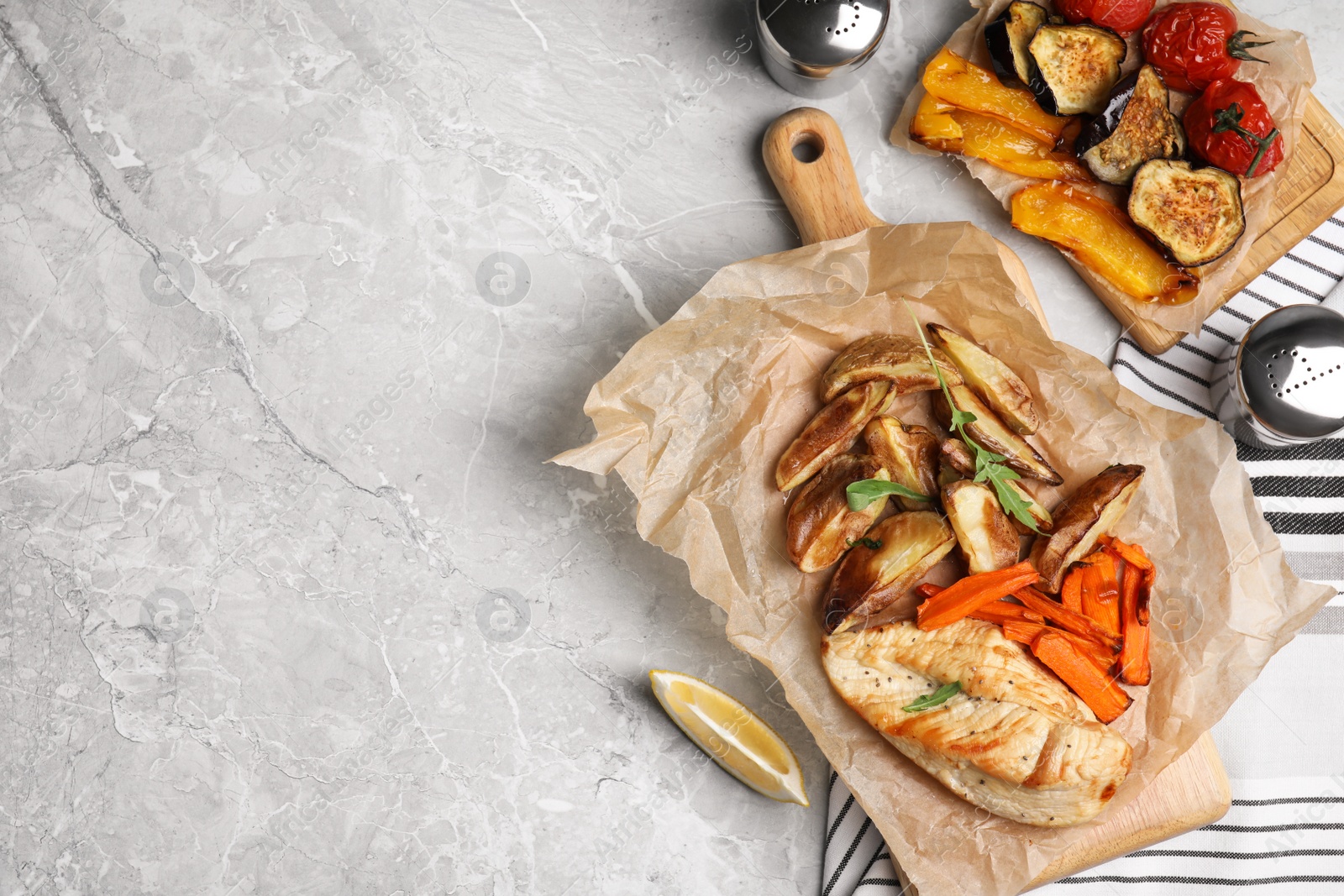 Photo of Delicious cooked chicken and vegetables on grey marble table, flat lay with space for text. Healthy meals from air fryer