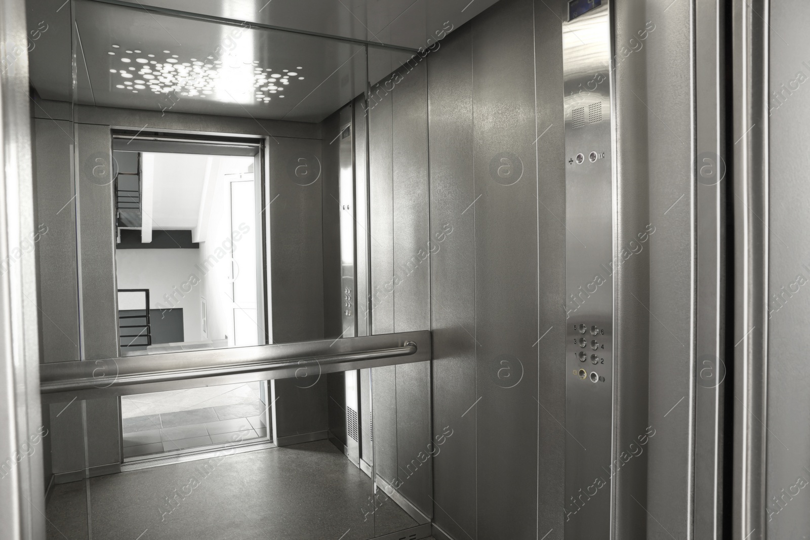 Photo of Open elevator`s cabin with big mirror indoors