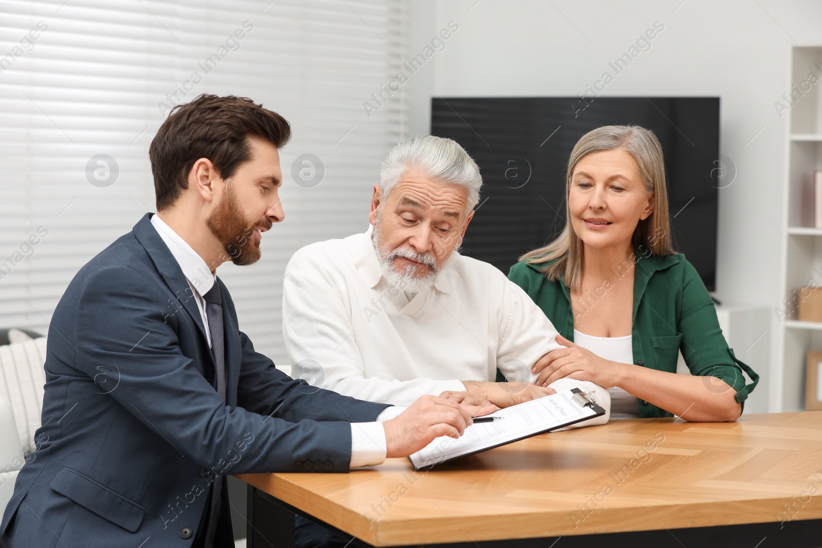 Photo of Notary consulting senior couple about Last Will and Testament in office