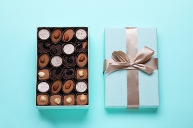 Photo of Open box of delicious chocolate candies on light blue background, flat lay