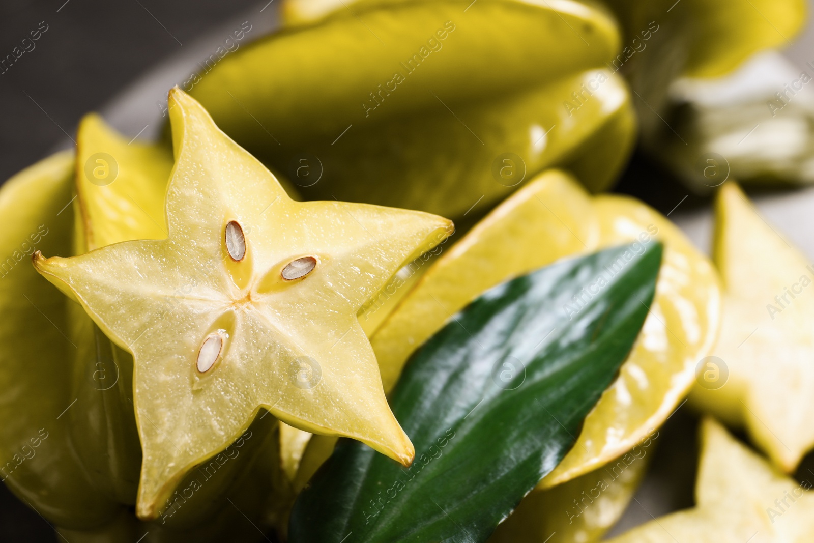 Photo of Cut and whole carambolas on table, closeup