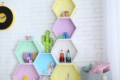 Colorful shelves near brick wall in child room interior