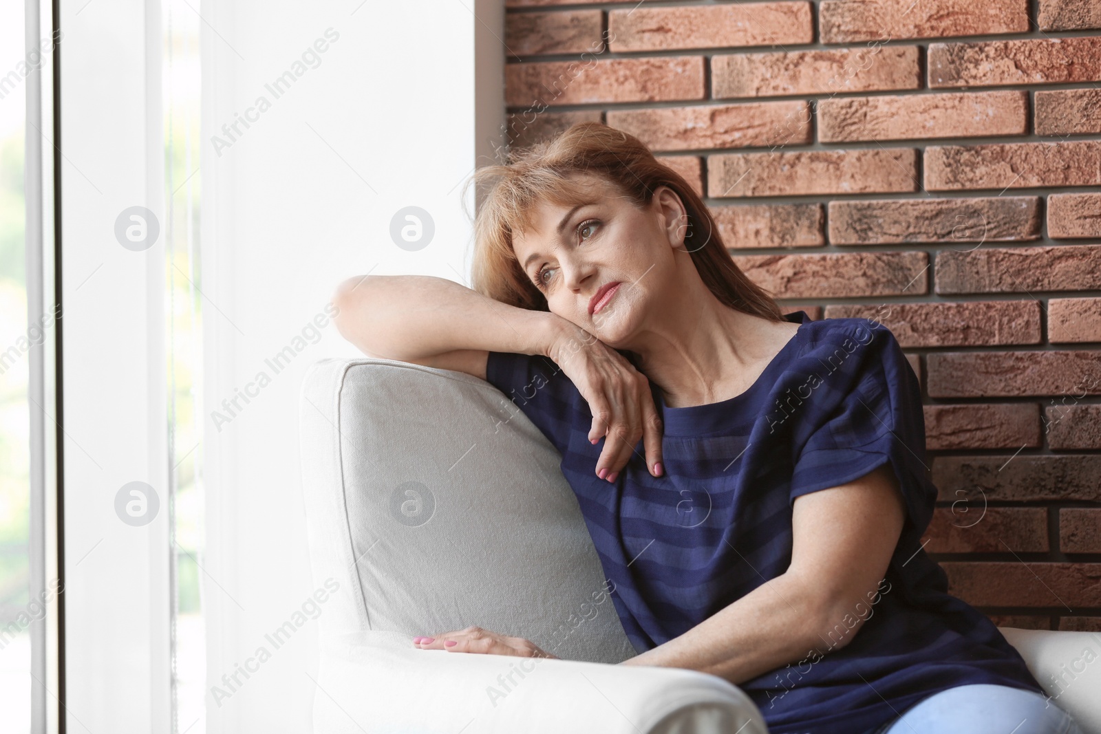 Photo of Senior woman suffering from depression in armchair