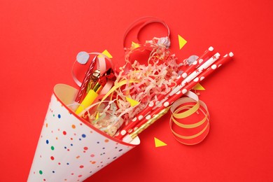 Photo of Party hat and different festive items on red background, flat lay