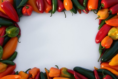 Frame of chili peppers on white background, flat lay. Space for text