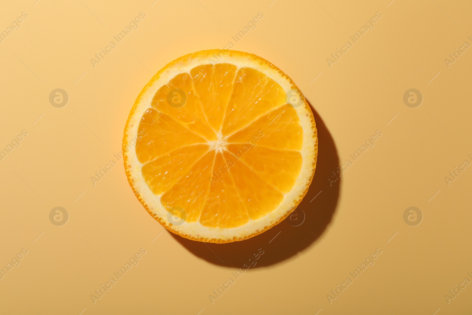 Photo of Slice of juicy orange on beige background, top view