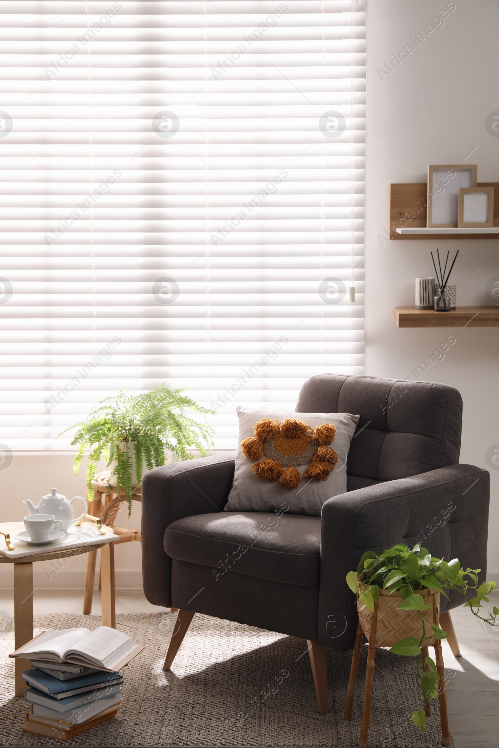 Photo of Comfortable place for rest with armchair near window in room