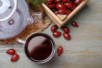 Flat lay composition with fresh dogwood tea and berries on wooden table. Space for text