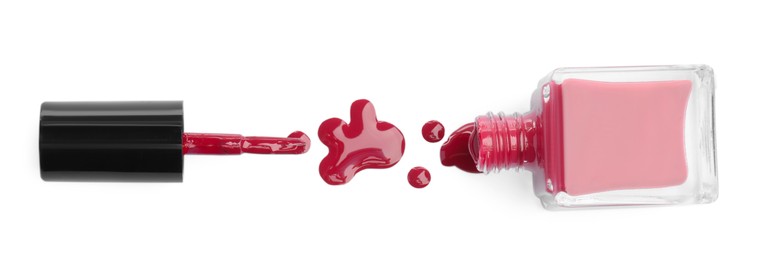 Photo of Bottle, brush and spilled red nail polish isolated on white, top view
