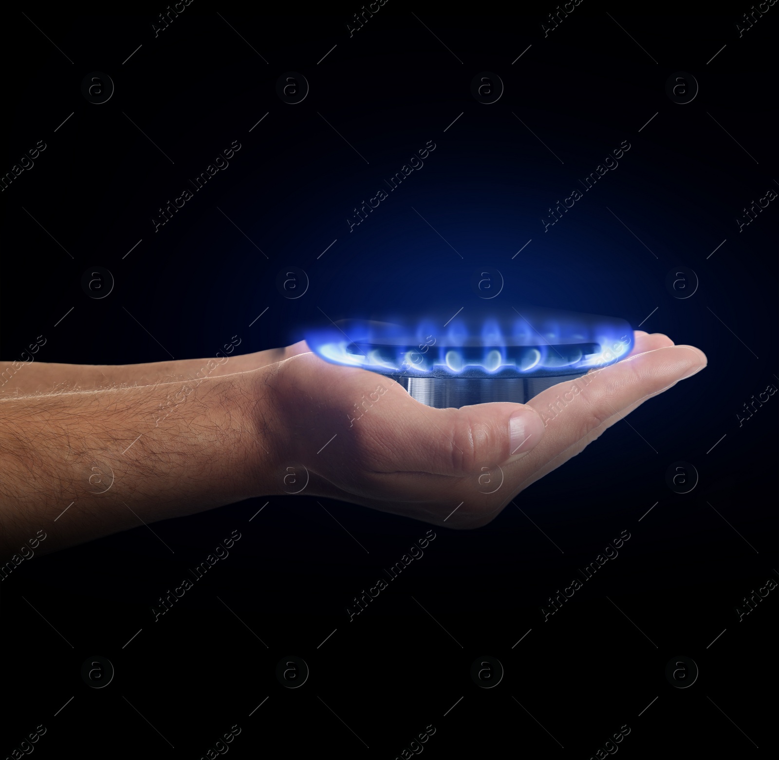 Image of Closeup view of man holding gas burner with blue flame on black background