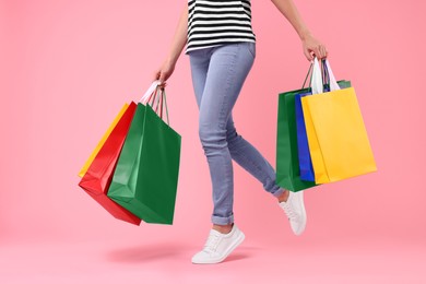 Photo of Woman with shopping bags on pink background, closeup