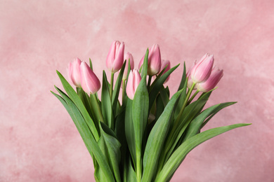 Photo of Bouquet of beautiful spring tulips on light pink background