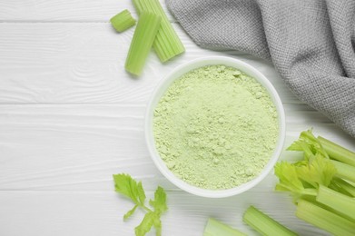 Photo of Natural celery powder in bowl and fresh stalks on white wooden table, flat lay. Space for text