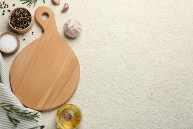 Photo of Wooden cutting board, oil and spices on white textured table, flat lay. Space for text