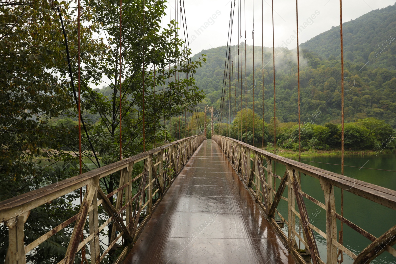 Photo of Beautiful view on rusty metal bridge over river in mountains