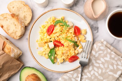 Photo of Delicious scrambled eggs, tofu and tomatoes served on white marble table, flat lay