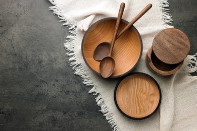 Photo of Stylish wooden dishware and spoons on grey table, flat lay. Space for text