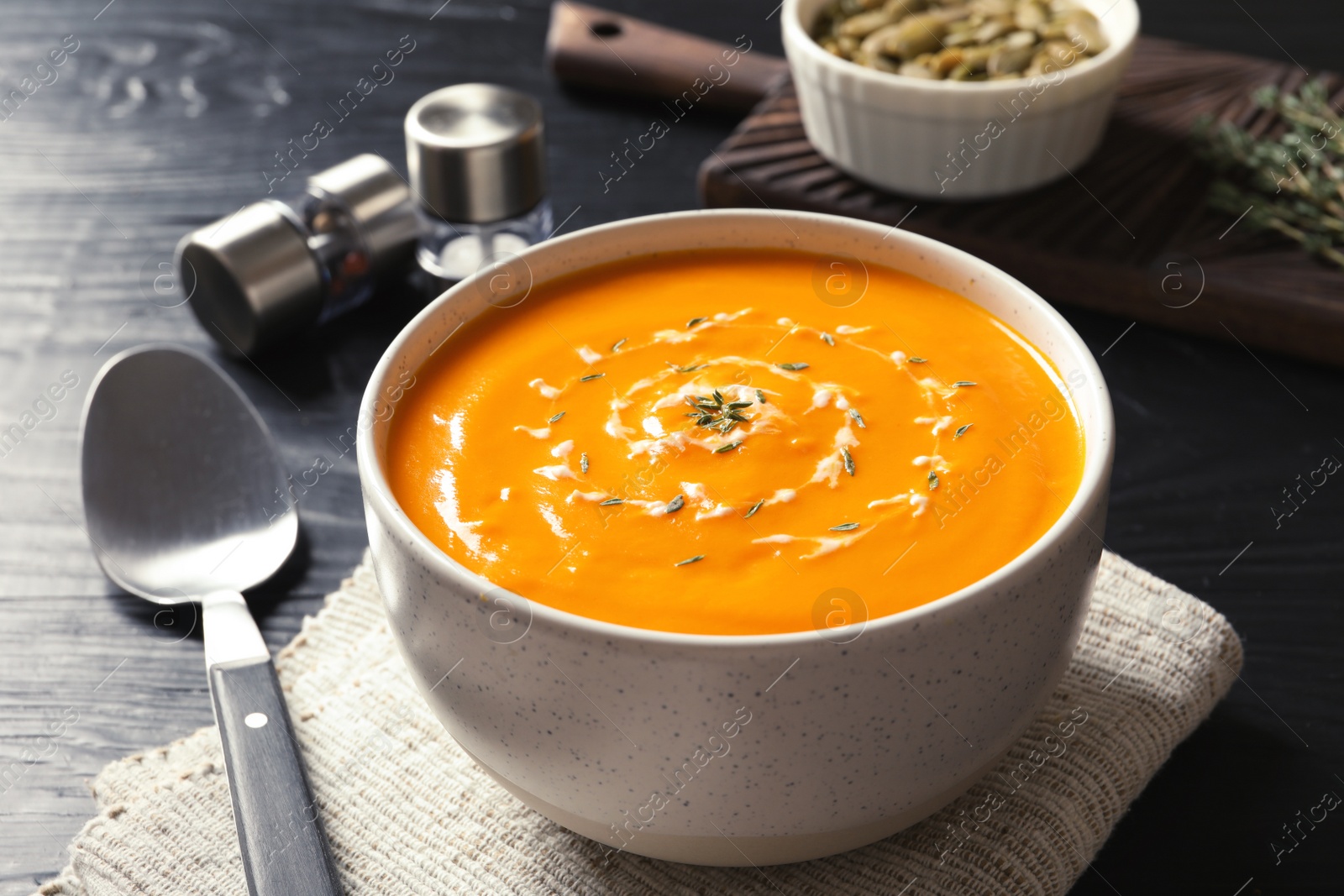 Photo of Delicious pumpkin cream soup in bowl on table