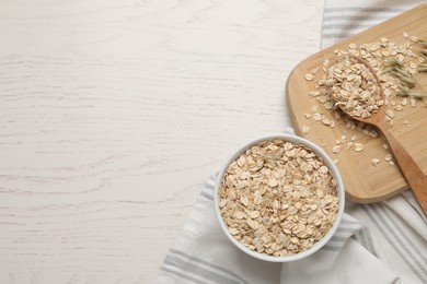 Photo of Oatmeal and florets on white wooden table, flat lay. Space for text