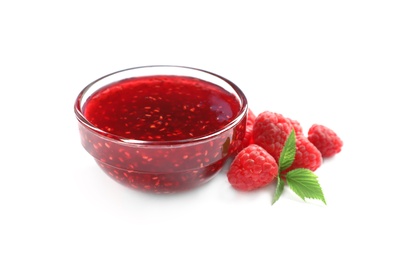 Photo of Bowl of sweet jam with ripe raspberries and green leaves on white background