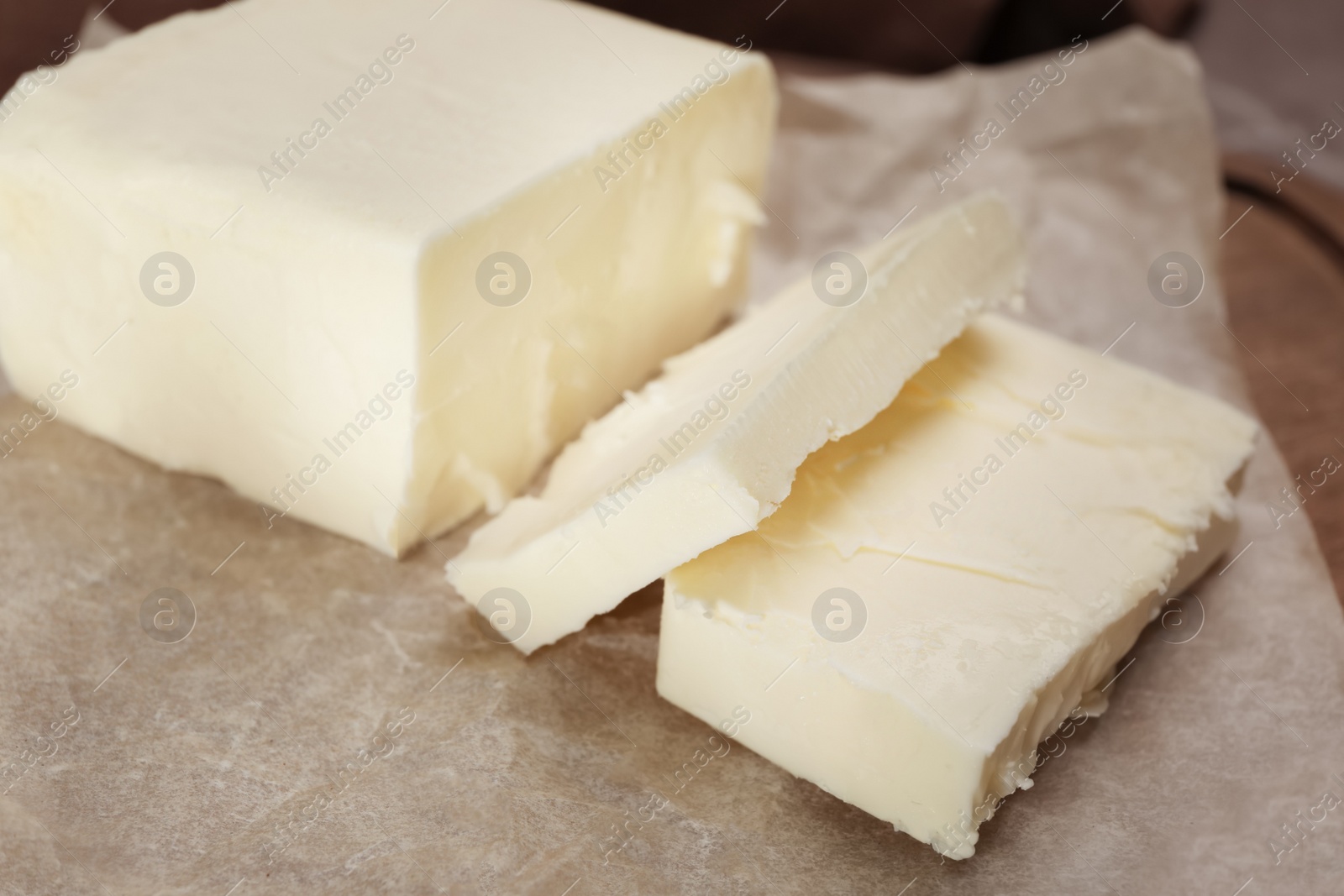 Photo of Tasty fresh cut butter on parchment, closeup